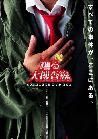 The poster features a person in a green jacket over a red shirt, with their hand resting on their chest. The title "Bayside Shakedown" is prominently displayed in bold red and white text. The background is dark, and the Japanese text adds to the mysterious atmosphere.