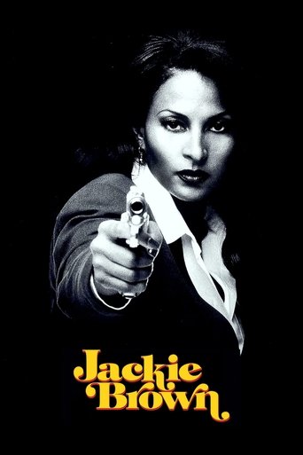 The poster features a woman in a dark suit pointing a gun forward against a stark black background. The title "Jackie Brown" is displayed in bold, golden-yellow text at the bottom. The mood is intense and suspenseful, with high contrast and dramatic lighting.