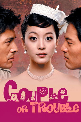 The poster features three individuals in a close-up, with the central woman looking directly at the camera. The background is warm and earthy, while the title "Couple or Trouble" is prominently displayed in pink and purple text. The overall mood suggests drama and intrigue.