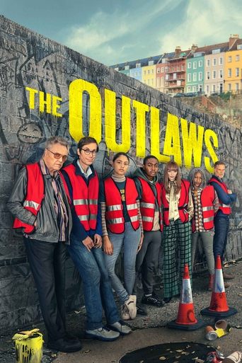 A group of six men in red vests and jeans stand proudly against a weathered stone wall, with colorful buildings in the background. The poster conveys a gritty, rebellious mood with bold yellow lettering and a sense of camaraderie among the outlaws.