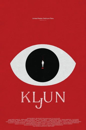 The poster features a striking red background with a large white eye containing a tiny silhouette of a person in the center. The title "Klun" appears in elegant white lettering below the eye, evoking mystery and intrigue. The minimalist design and bold color scheme create a suspenseful and myster...