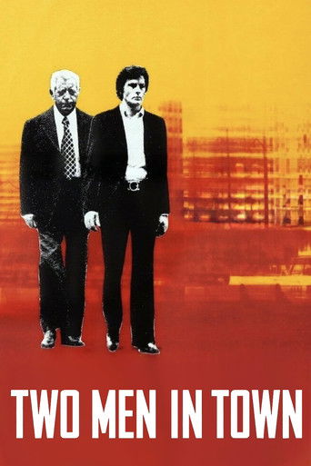 The poster features two men in dark suits walking side by side against a vibrant orange and red gradient background. The mood is tense yet mysterious, suggesting a thriller or crime drama. The bold text at the bottom reinforces the film's gritty, urban setting.