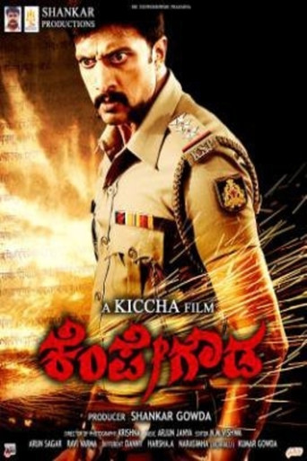 The poster features a powerful image of Shankar Gouda in his military uniform, exuding authority and determination. The warm golden hues and dramatic lighting create a sense of intensity and heroism. The bold red title text adds to the dramatic and impactful atmosphere, emphasizing the film's the...