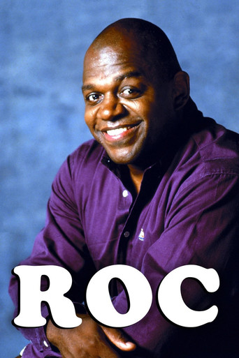 A smiling man in a purple shirt stands against a blue background, with the word "ROC" prominently displayed in large white letters. The image conveys a warm, inviting mood.