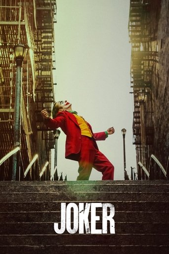 The poster features a Joker in a red suit and yellow jacket, striking a dramatic pose against a backdrop of towering brick buildings. The muted, sepia-toned atmosphere evokes a sense of urban decay and melancholy, while the bold white text "JOKER" anchors the image with a stark, unsettling tone.