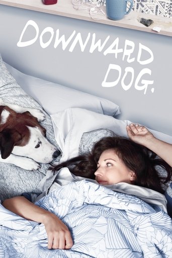 A young woman lies in bed with her dog, both looking up at the camera. The poster features soft blue bedding and a cozy, intimate mood. The title "Downward Dog" is written in elegant white script.