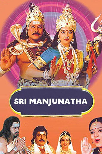 The poster features a vibrant scene with a man in traditional attire and a woman adorned in golden jewelry, set against a radiant purple background. The title "SRI MANJUNATHA" is prominently displayed in bold text, evoking a sense of divine grandeur and spiritual significance. The overall composi...