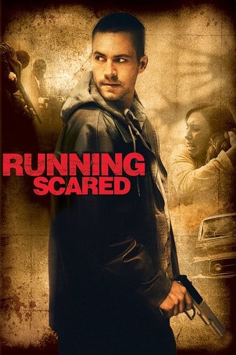The poster features a determined man in a dark jacket holding a gun, with a gritty, sepia-toned background. The bold red text "RUNNING SCARED" stands out against the muted tones, evoking a sense of urgency and danger.