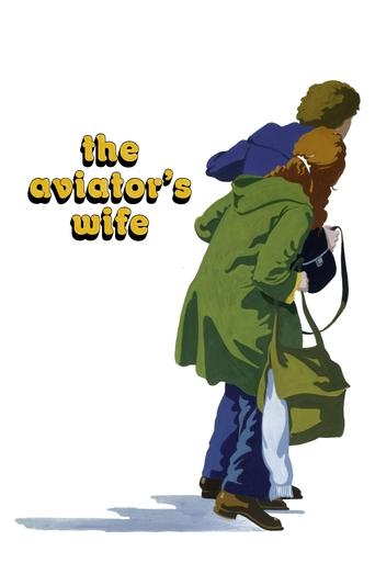 The poster features a man in a green coat carrying a woman in a blue jacket, evoking a sense of urgency and adventure. The title "The Aviator's Wife" is prominently displayed in bold, yellow text against a stark white background. The overall composition suggests a dramatic and possibly tense narr...