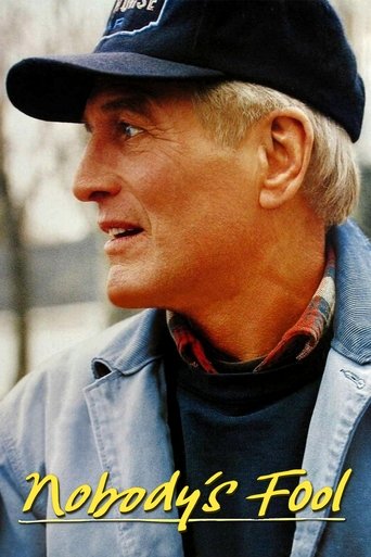 The poster features a contemplative man in a blue cap and denim jacket, exuding a sense of mystery and intrigue. The warm, golden lighting enhances the film's dramatic and suspenseful atmosphere.