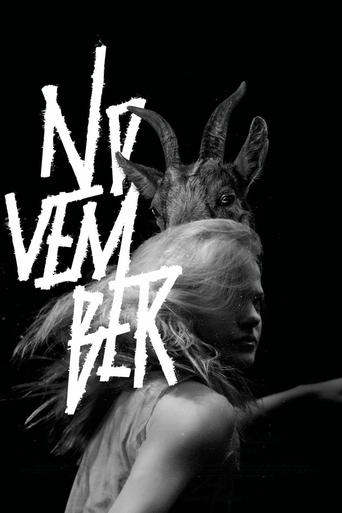 A striking black-and-white poster features a woman with goat horns, her face partially obscured by the bold, white text "NO VEM BER." The moody lighting and dramatic composition evoke a sense of mystery and intrigue.