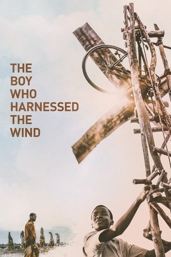 This movie poster features a striking composition with a large wooden windmill dominating the right side, its weathered texture and golden light creating a dramatic focal point. In the foreground, a young boy with a determined expression looks up at the windmill, while a distant figure stands on ...