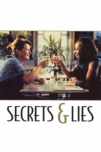 The poster features two women sharing a toast at a restaurant, with warm lighting and a cozy atmosphere. The title "Secrets & Lies" is prominently displayed in elegant gold lettering against a dark background.
