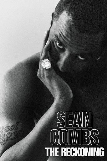 The poster features a moody, black-and-white portrait of Sean Combs, his face partially shadowed and his hand resting near his cheek, exuding a sense of introspection and mystery. The text "SEAN COMBS" and "THE RECKONING" are prominently displayed in bold, white capital letters against the dark b...