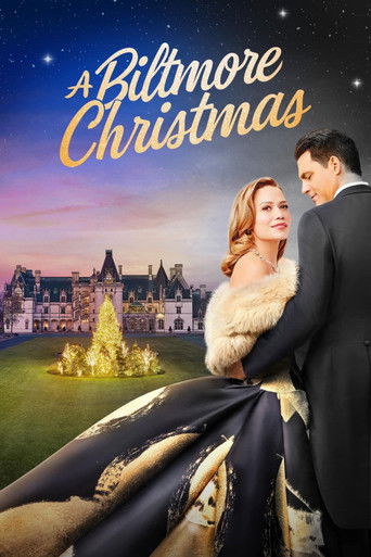 A romantic couple stands in front of a grand Biltmore mansion under a starry night sky. The warm tones of their dresses and the golden glow of the Christmas tree evoke a cozy holiday atmosphere.