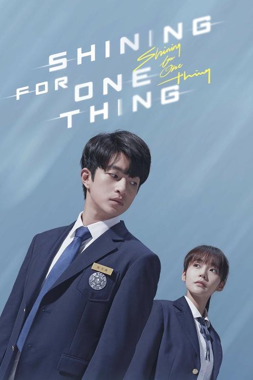 The poster features two young men in matching navy suits against a soft blue gradient background. The title "Shining For One Thing" is elegantly displayed in white and yellow text, with a subtle star symbol. The mood is hopeful and inspiring, evoking themes of unity and shared dreams.