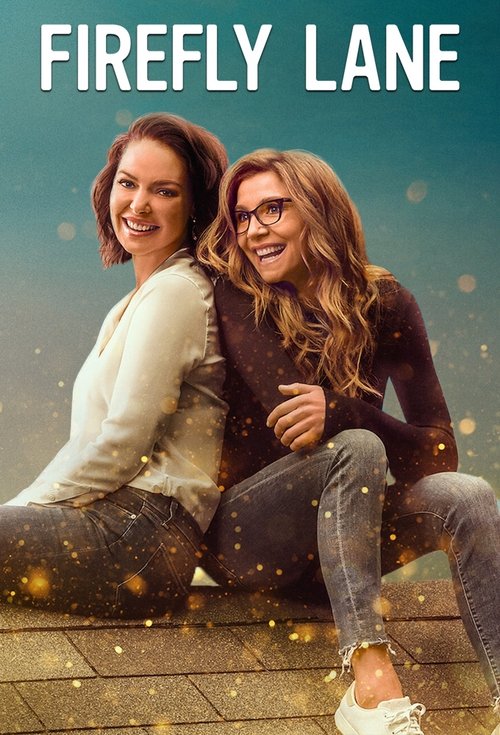 Two women sit on a wooden deck, laughing and posing for the camera. The poster features warm tones of orange, yellow, and soft brown, evoking a cozy, nostalgic atmosphere. The title "Firefly Lane" is prominently displayed at the top in bold, white letters.