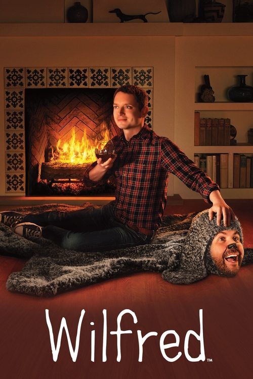 The poster features a man in a plaid shirt kneeling beside a man in a gray sweater, both smiling warmly against a cozy fireplace backdrop. Warm tones of red, brown, and beige evoke a nostalgic, heartwarming atmosphere. The title "Wilfred" is elegantly displayed at the bottom, suggesting a classic...