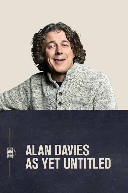 The poster features a warm, smiling Alan Davies in a textured gray sweater against a soft beige background. A dark blue strip at the bottom displays his name in bold white text, conveying a sense of understated elegance and timeless appeal.