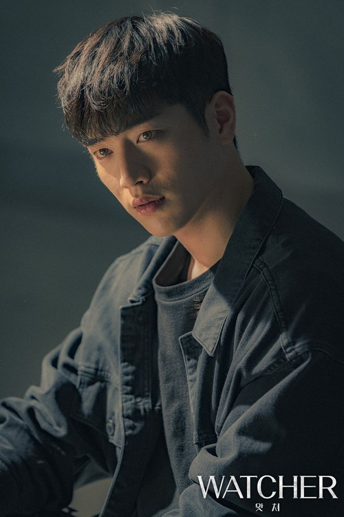 The poster features a young man with dark hair and a contemplative expression, wearing a dark jacket over a gray shirt. The muted tones and soft lighting create a somber mood, suggesting themes of introspection or mystery.