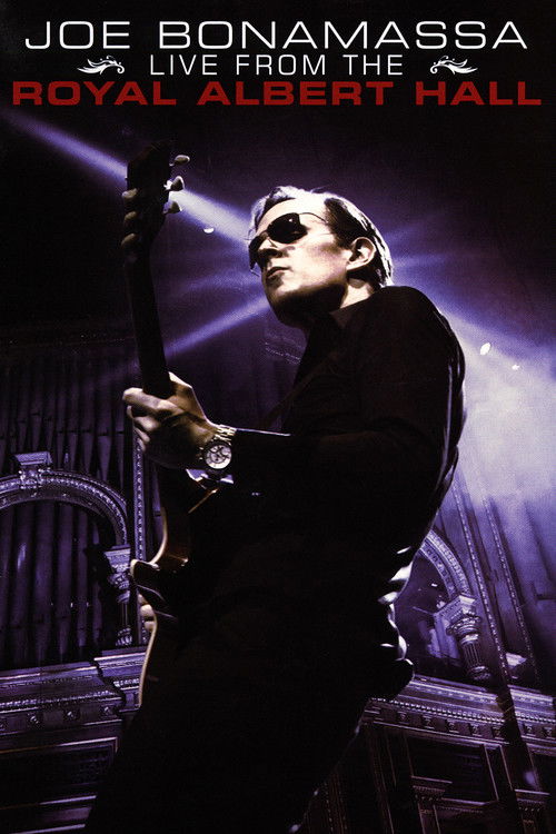 Joe Bonamassa, wearing sunglasses and a black outfit, passionately plays an electric guitar on stage at the Royal Albert Hall. The image captures a dramatic concert atmosphere with purple lighting and a sense of intense emotion.
