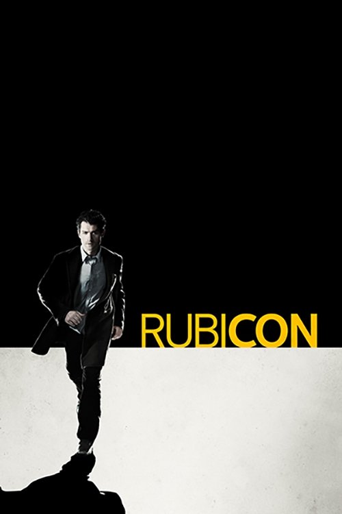 A silhouette of a man in a suit stands against a stark black background, with the word "RUBICON" in bold yellow letters below. The image conveys a mysterious and dramatic mood, emphasizing the show's gritty and intense atmosphere.