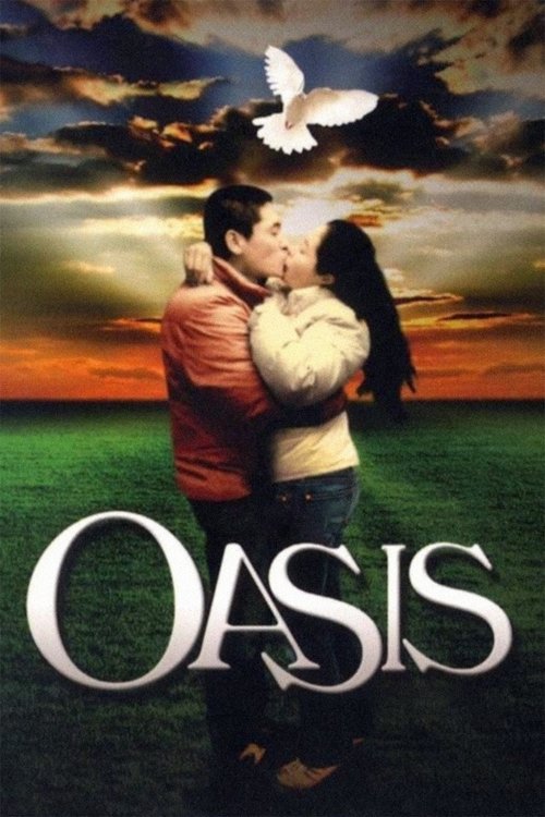 The poster features a tender moment between two people embracing against a dramatic sunset sky, with a white dove soaring above. The warm hues of orange and pink blend with deep blues, evoking a sense of hope and romance. The title "OASIS" is prominently displayed in bold, white letters at the bo...