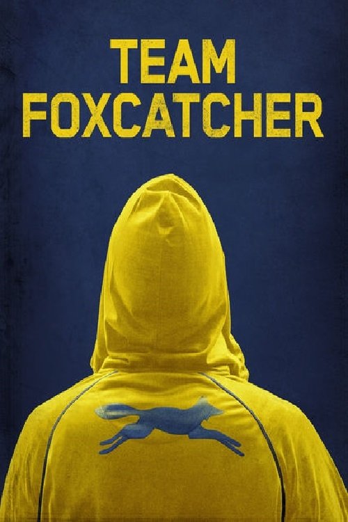 The poster features a person in a bright yellow hoodie against a dark blue background, with the title "TEAM FOXCATCHER" prominently displayed in bold yellow letters. The image evokes a sense of mystery and intrigue, suggesting an action-packed narrative.