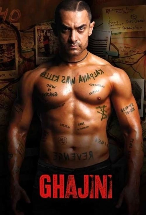 The poster features a muscular man with tattoos, exuding strength and intensity. The warm, golden lighting enhances the dramatic atmosphere. Bold red text at the bottom reads "GHAJINI," suggesting a powerful and intense narrative.