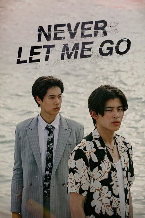 The poster features two young men standing against a beach backdrop. The man on the left wears a gray suit and tie, while the man on the right sports a black-and-white floral shirt. The text "NEVER LET ME GO" is prominently displayed at the top in bold, white letters. The overall mood is somber a...