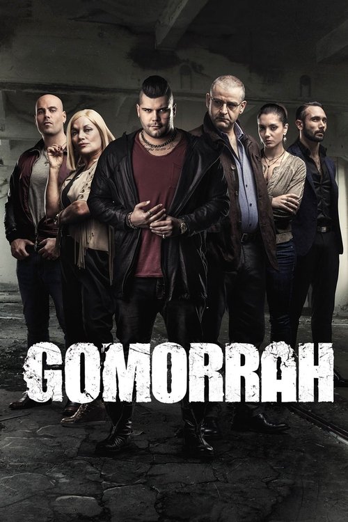 The poster features a group of six men and women standing in a dimly lit, gritty urban setting. The mood is tense and mysterious, with dark tones and shadows enhancing the suspenseful atmosphere. The title "GOMORRAH" is prominently displayed in bold, white letters at the bottom, suggesting a horr...