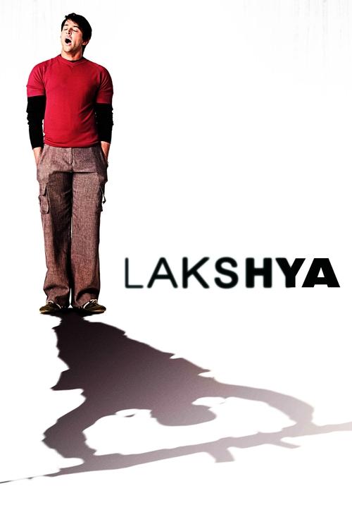 The poster features a man in a red sweater and brown pants standing against a stark white background, casting a dramatic shadow. The bold black text "LAKSHYA" dominates the lower right, evoking mystery and intrigue. The minimalist design and intense lighting create a suspenseful mood, hinting at ...