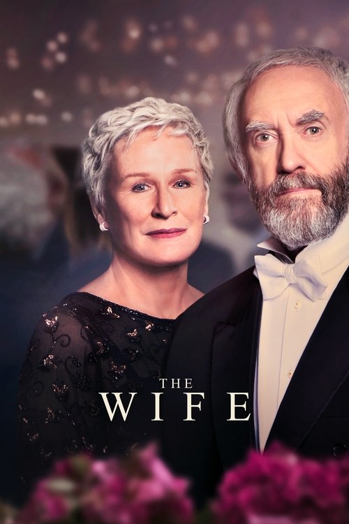 The poster features a glamorous couple in formal attire against a softly lit, romantic backdrop. The woman with short gray hair and the man with a beard exude elegance, while the title "The Wife" is elegantly displayed in white lettering. The overall mood is one of sophistication and timeless rom...