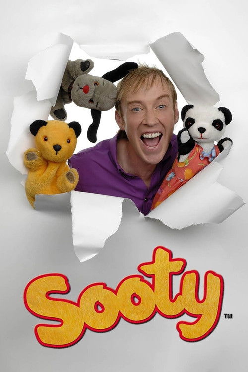 The poster features a joyful man in purple peeking through torn paper, surrounded by colorful plush toys including a bear, a panda, and a dog. The bright orange "Sooty" logo at the bottom adds a playful, energetic tone, capturing the show's lively and humorous spirit.