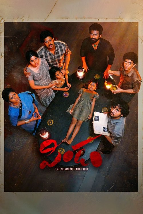The poster features a group of seven characters gathered around a table, each holding a small fire. The warm, golden lighting creates a cozy atmosphere, while the dark background adds depth. The title "Pindam" is prominently displayed in bold red letters, emphasizing the film's intense and dramat...