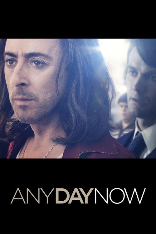 The poster features a man with long hair and a serious expression, set against a blurred background of other characters. The warm tones and dramatic lighting evoke a sense of mystery and intrigue. The title "Any Day Now" is prominently displayed at the bottom, suggesting a film about everyday lif...