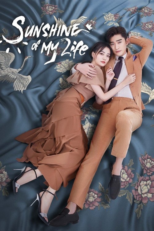 The poster features two elegantly dressed individuals in a romantic pose against a floral-patterned blue background. The warm tones of their clothing contrast with the cool blue backdrop, creating a visually striking composition that evokes a sense of intimacy and romance.