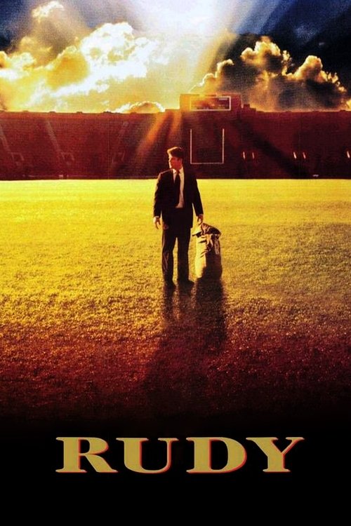 The poster features a solitary figure in a dark suit walking through a golden field under a dramatic sky filled with fiery clouds. The warm, golden hues evoke a sense of hope and nostalgia, while the silhouette of a dog adds a touch of innocence and companionship. The title "Rudy" is prominently ...