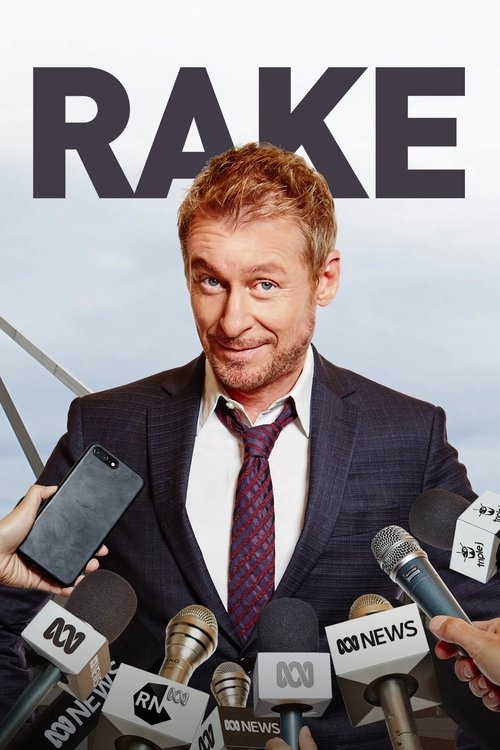 The poster features a man with reddish hair and a suit, surrounded by numerous microphones from various media outlets. The bold, dark text "RAKE" dominates the top, creating a dramatic and serious tone. The overall mood is professional yet slightly mysterious, suggesting a high-stakes narrative.