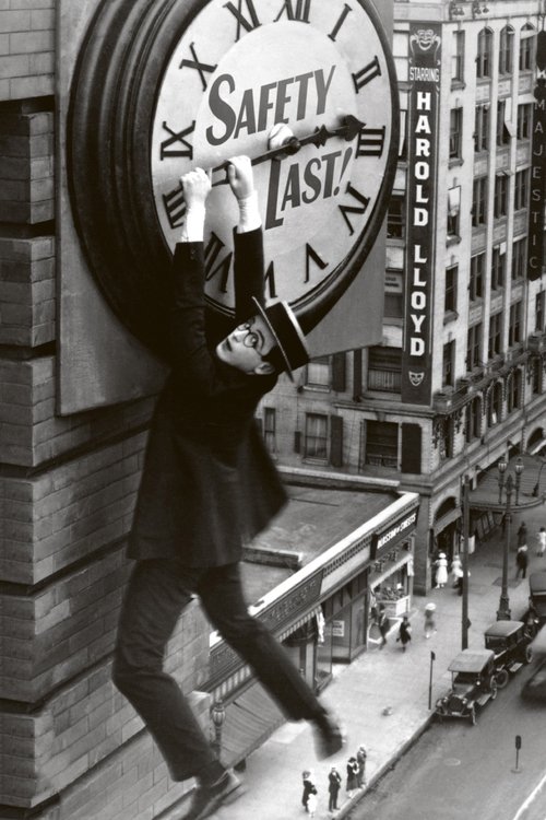 In a gritty black-and-white cityscape, a lone figure in a trench coat and boots leaps from a rooftop, clutching a giant safety clock that reads "SAFETY LAST!" The scene captures a tense, dramatic moment with a somber mood, emphasizing the urgency of the message amidst urban decay.