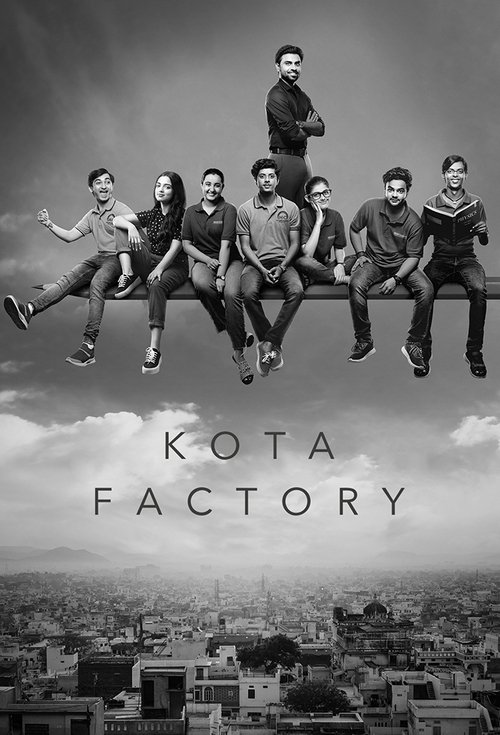 The poster features a group of young people sitting on a long bench against a dramatic sky, with one person standing atop the bench. The image is monochromatic, emphasizing the mood of mystery and intrigue. The title "Kota Factory" is prominently displayed below, suggesting a blend of urban and i...