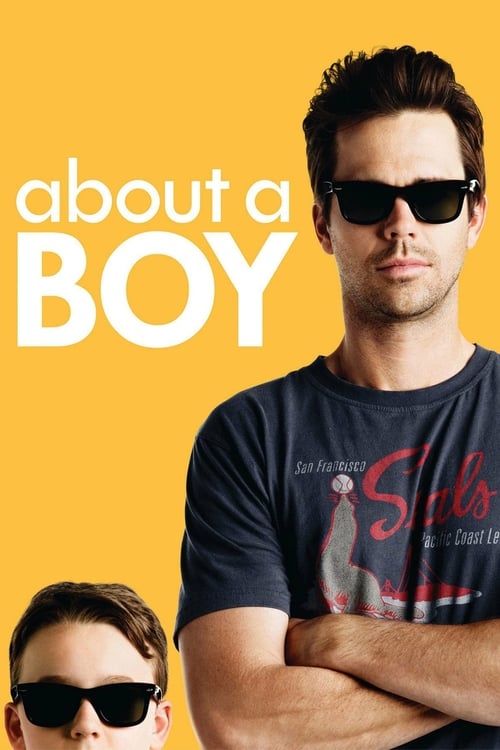 The poster features two young men in sunglasses against a vibrant yellow background. The larger man stands confidently with arms crossed, while the smaller boy sits below him, both exuding youthful energy. The bold white text "about a boy" dominates the composition, evoking a playful yet serious ...