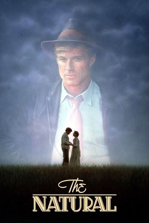 The poster features a large, ghostly figure of a man in a hat against a stormy sky, while a small couple stands in the foreground amidst tall grass. The colors are muted blues and greens, creating a somber, mysterious atmosphere. The title "The Natural" is elegantly displayed at the bottom.