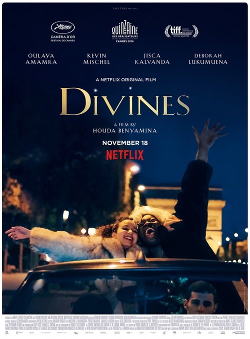 The poster features a dramatic scene with a woman in a convertible car, her hand raised as if reaching for something unseen. The dark, moody atmosphere is enhanced by the warm glow of streetlights and the eerie, otherworldly figure in the background. The title "Divines" is prominently displayed i...