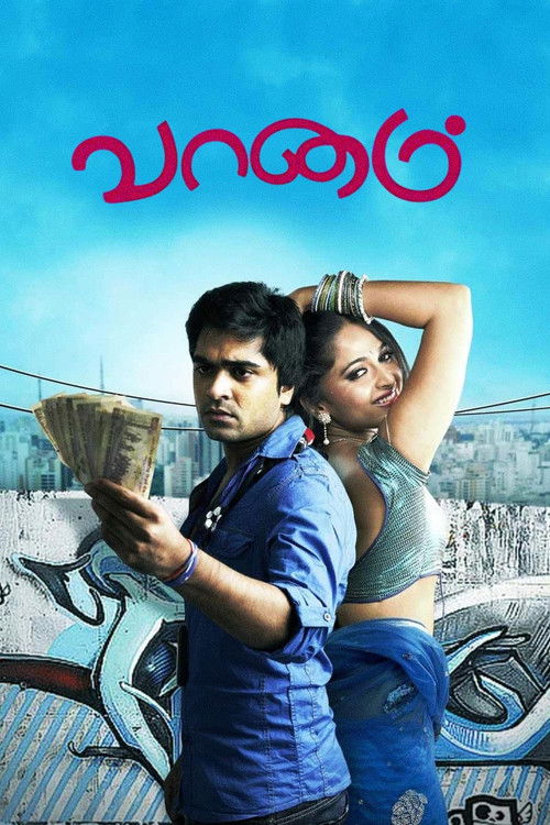 The poster features a young man in a blue shirt holding a book, with a woman in a green top and blue skirt standing behind him. The background shows a cityscape under a bright blue sky, creating a vibrant and dynamic atmosphere. The title "Vaanam" is prominently displayed in red at the top.