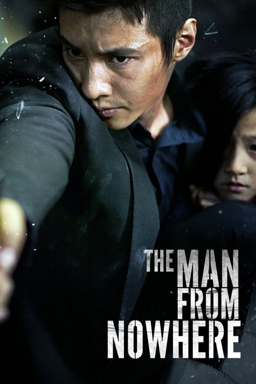 The poster features a determined man in a dark suit, with a woman and child in the background, all set against a dark, moody backdrop. The title "The Man from Nowhere" is prominently displayed in bold white letters. The overall mood is intense and suspenseful, suggesting a thriller or action movie.