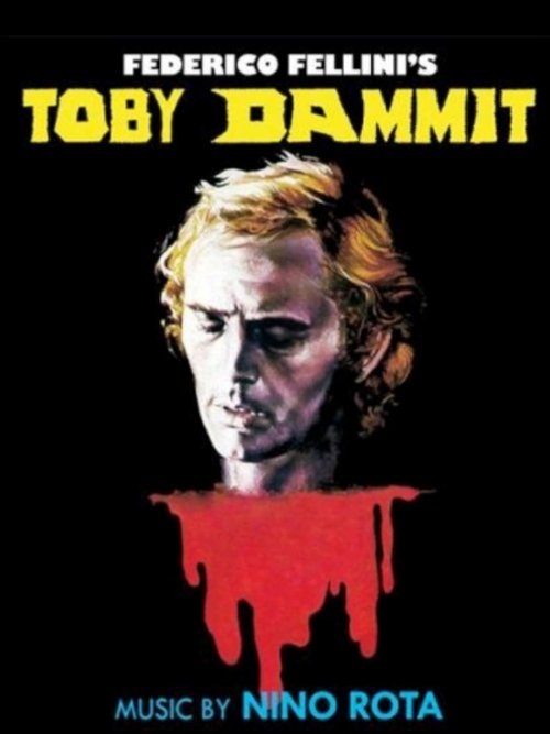 The poster features a menacing face against a stark black background, with the title "Toby Dammit" in bold yellow letters. A dripping red blood effect adds a sinister touch, while the name "Federico Fellini's" hints at the film's directorial flair. The overall mood is dark and ominous, evoking a ...