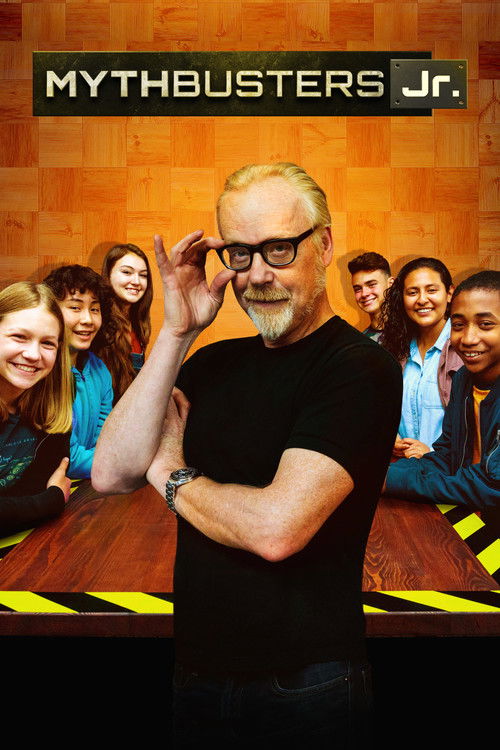 The poster features a confident man in glasses and a black shirt, with a group of diverse children behind him. The warm orange background and bold yellow caution tape add a playful, investigative tone. The mood is energetic and engaging, inviting viewers to join the Mythbusters Jr. team.