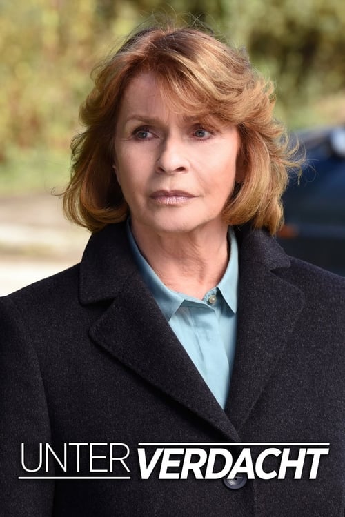 A woman with reddish-brown hair stands in front of a blurred outdoor background, wearing a dark coat over a light blue shirt. Her serious expression and somber tone convey a sense of mystery and intrigue, fitting the show's theme of investigation and suspense.