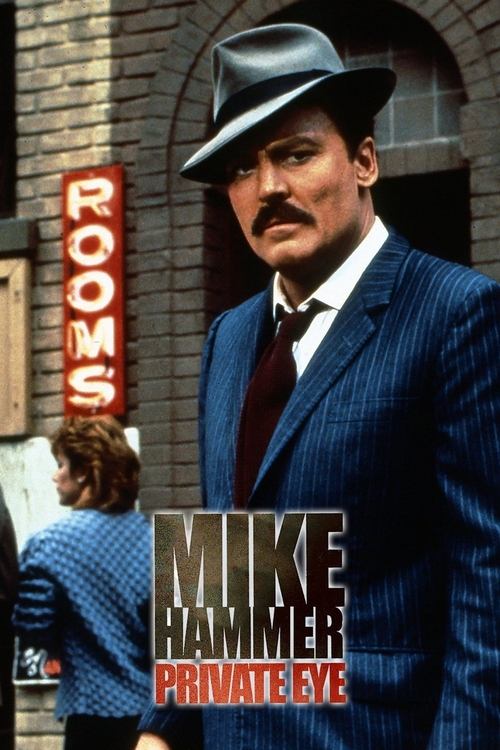The poster features Mike Hammer in a sharp blue suit and black hat, exuding authority. A red neon sign reading "ROOMS" adds a gritty, urban atmosphere. The dark, moody lighting enhances the dramatic tension, capturing the essence of a classic detective story.